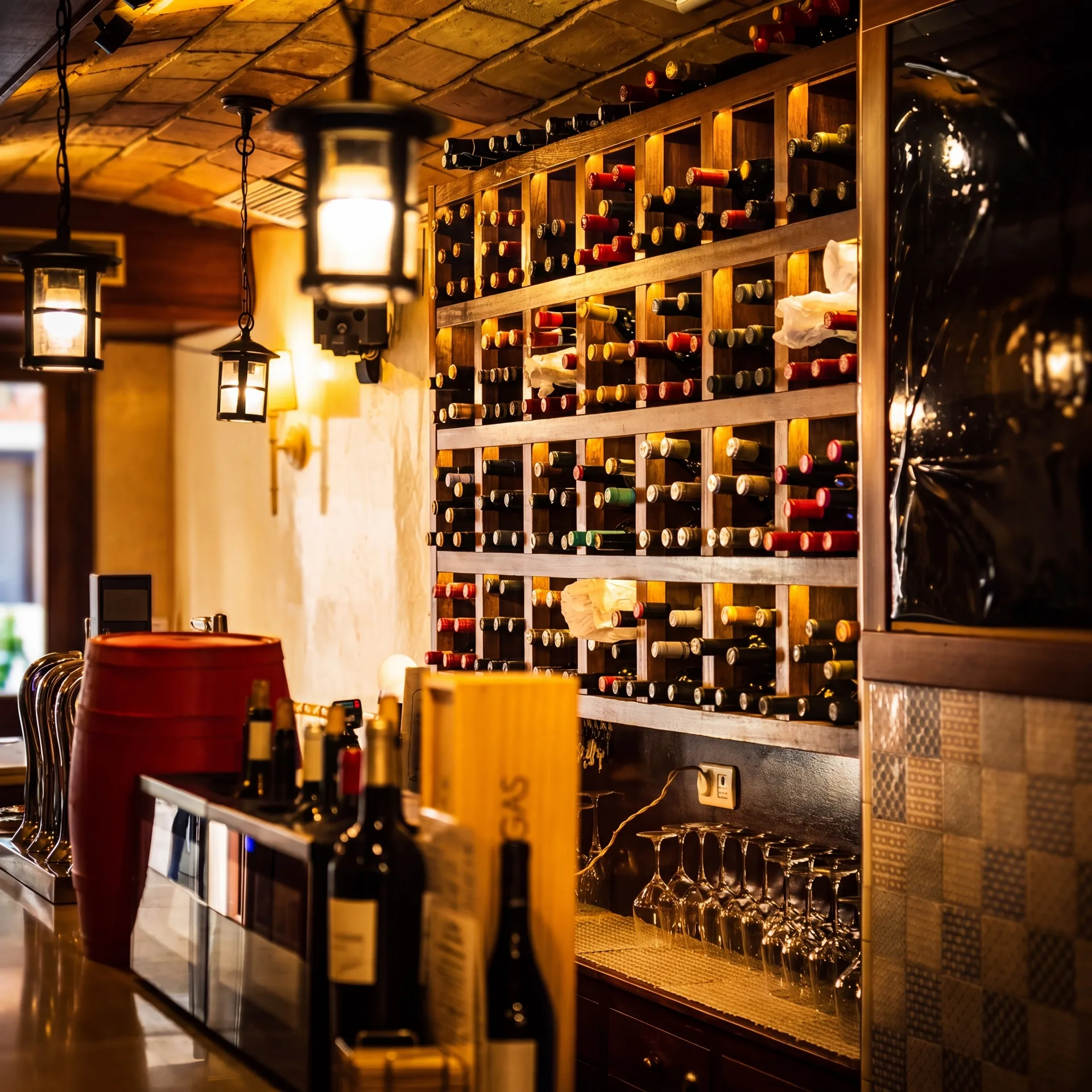 Sala principal y pared de botellas de Bodega Los Tintos, taberna de vinos y tapas en el Realejo, Granada